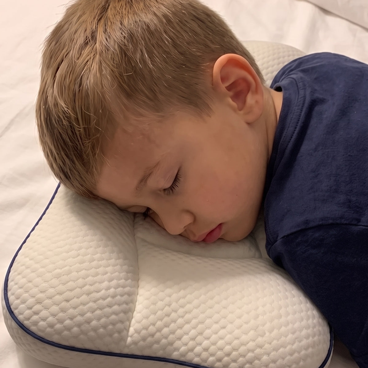 Un garçon endormi sur l’oreiller enfant